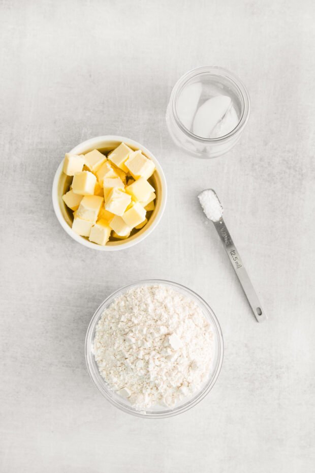 Flour, salt, butter, and ice water on a table.