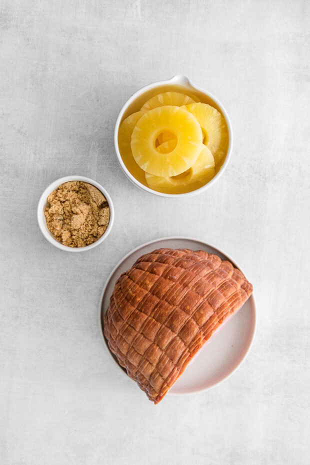 Ham, pineapple rings, and brown sugar sitting on a table. 