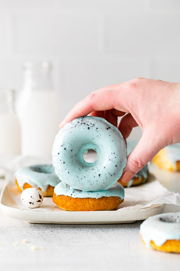 A hand holding a Robin's Egg Baked Donut.