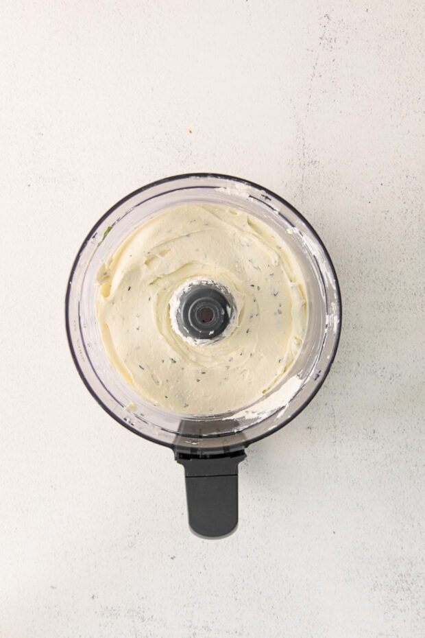 Whipped feta with herbs in a food processor.