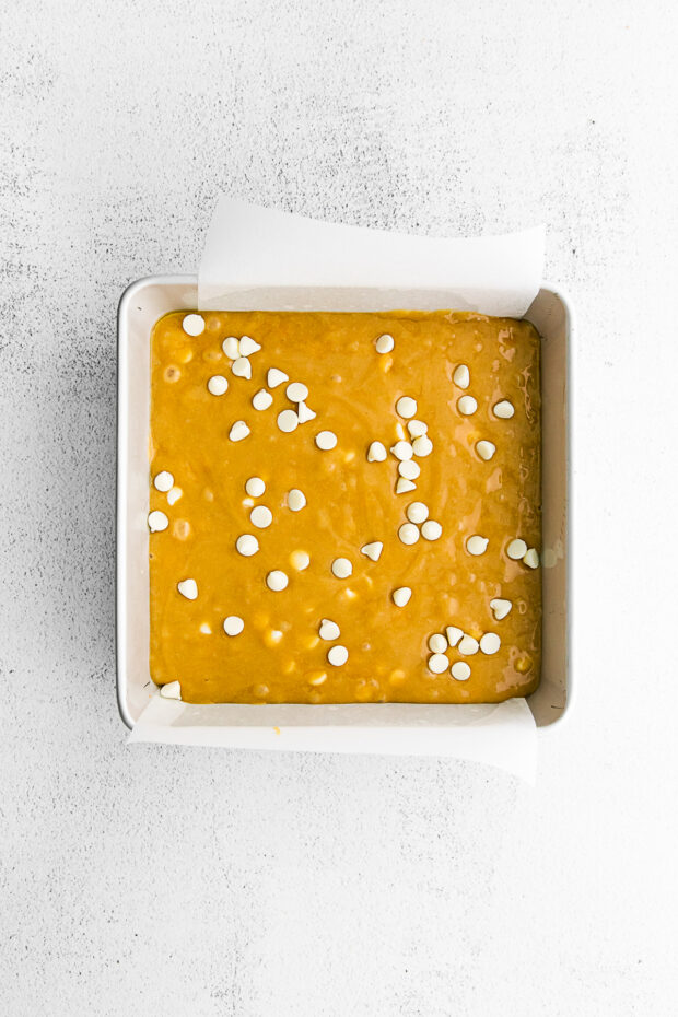 Uncooked White Chocolate Chip Blondies in a 9x9 pan. 