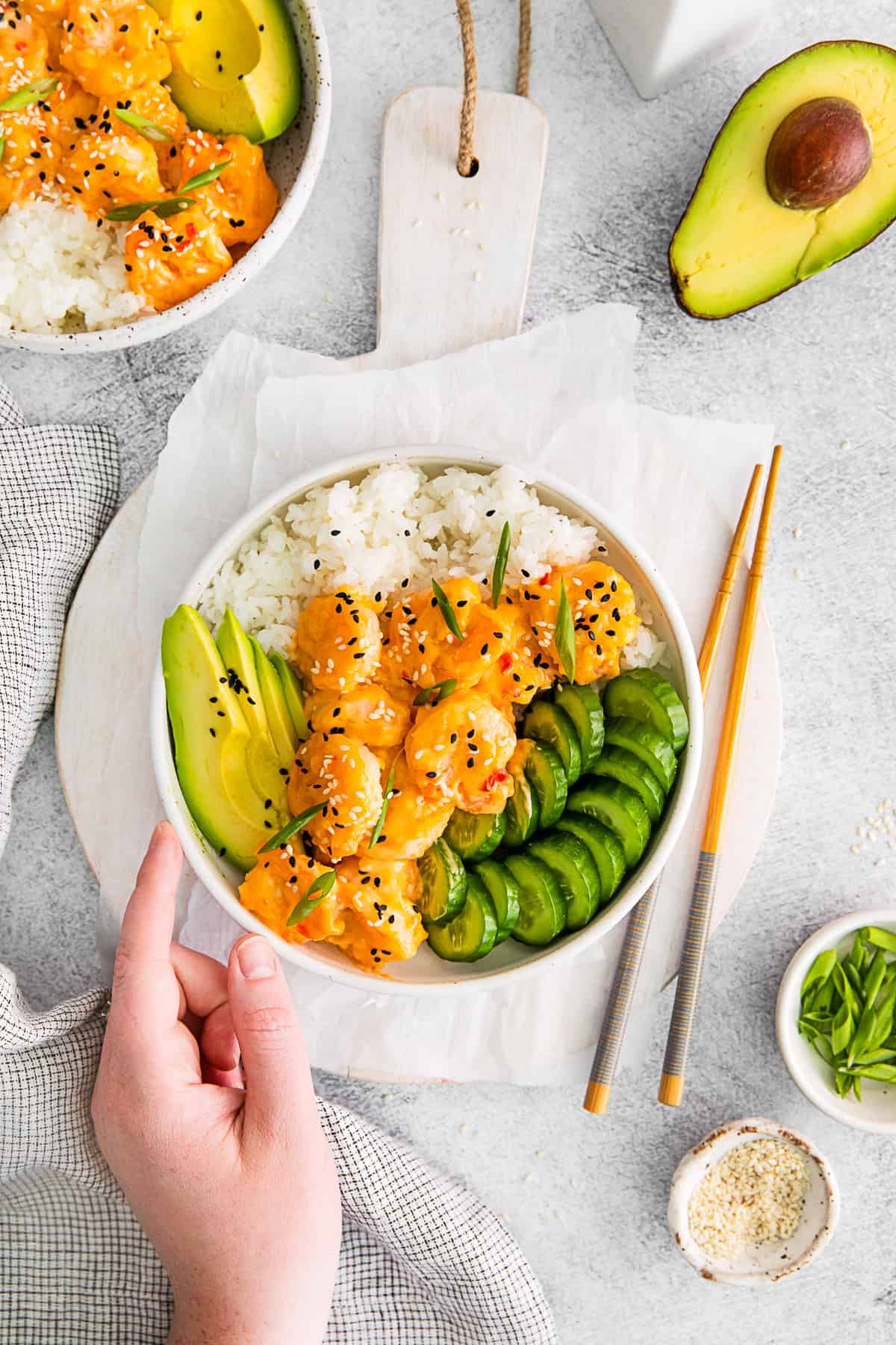 A hand holding a Bang Bang Shrimp Bowl.