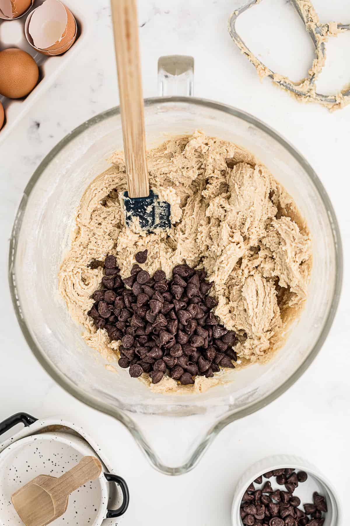 Chocolate chips getting folded into cookie batter. 