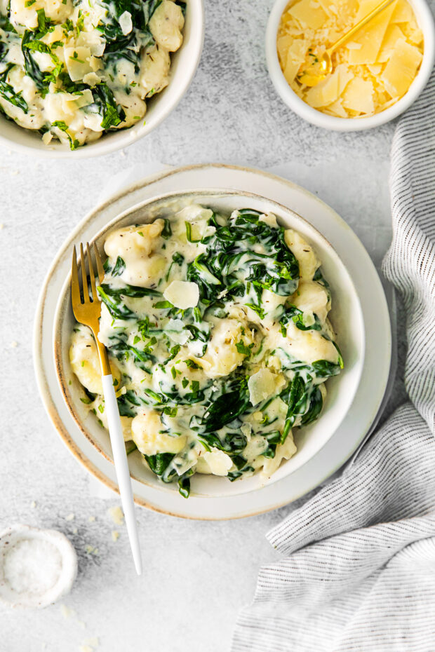 Creamy Spinach Gnocchi in a bowl with a fork.