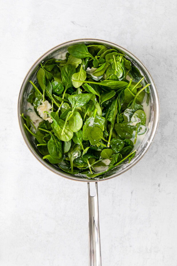 Spinach in cream sauce in a pan.