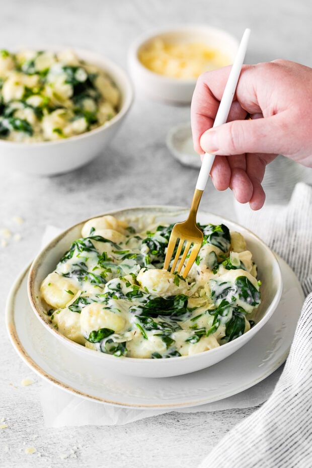 A fork picking up a piece of gnocchi.
