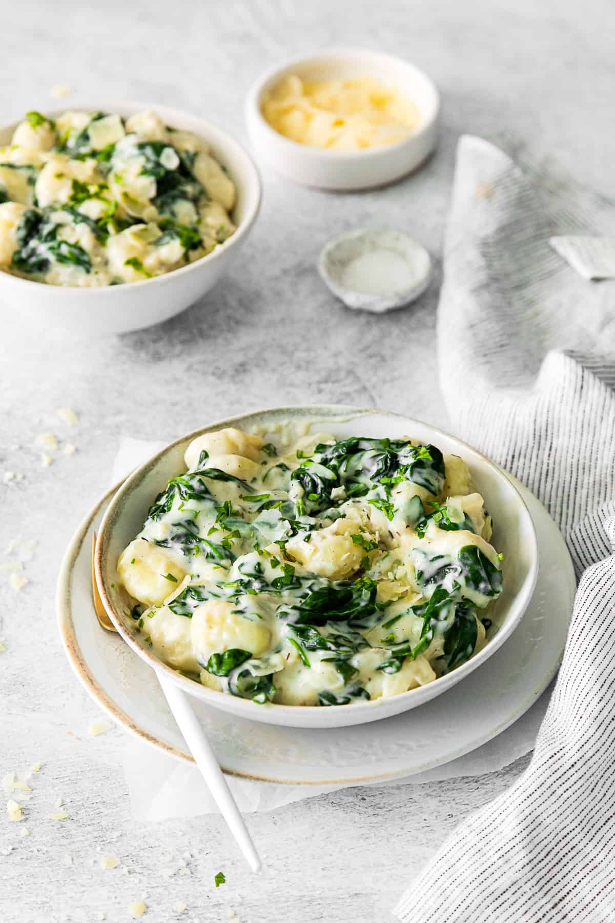 Creamy Spinach Gnocchi garnished with parmesan.