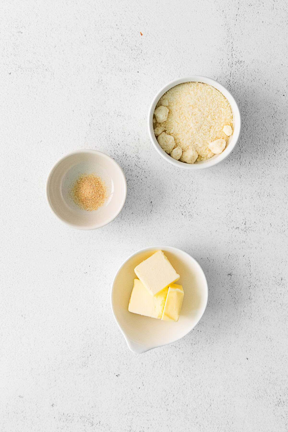 Ingredients to make garlic parmesan topping on a table.