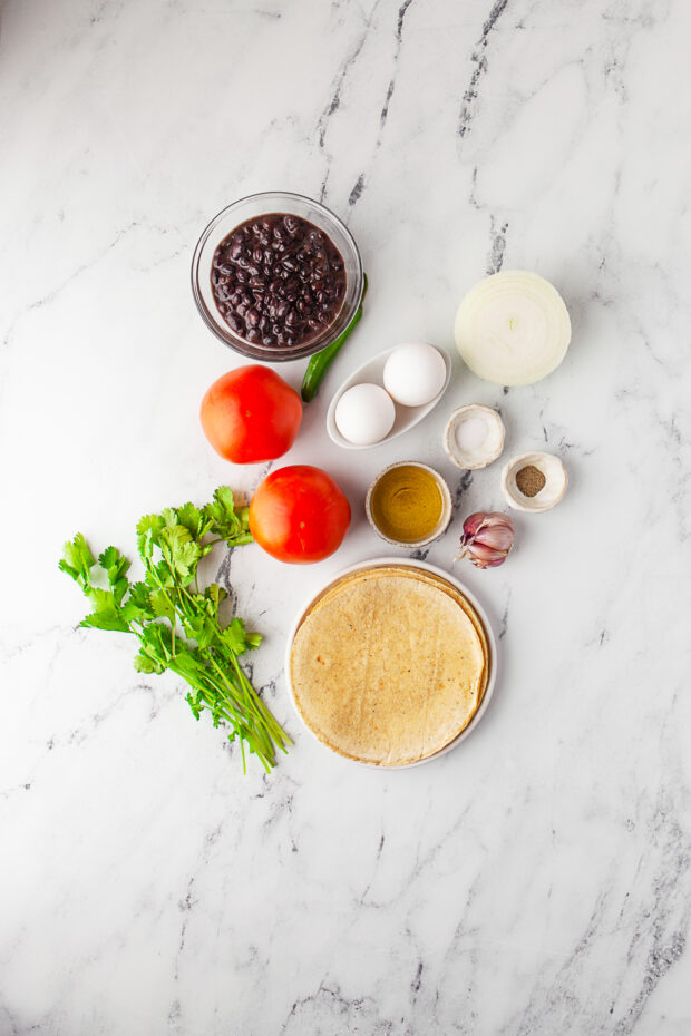 Ingredients to make Huevos Rancheros on a table. 