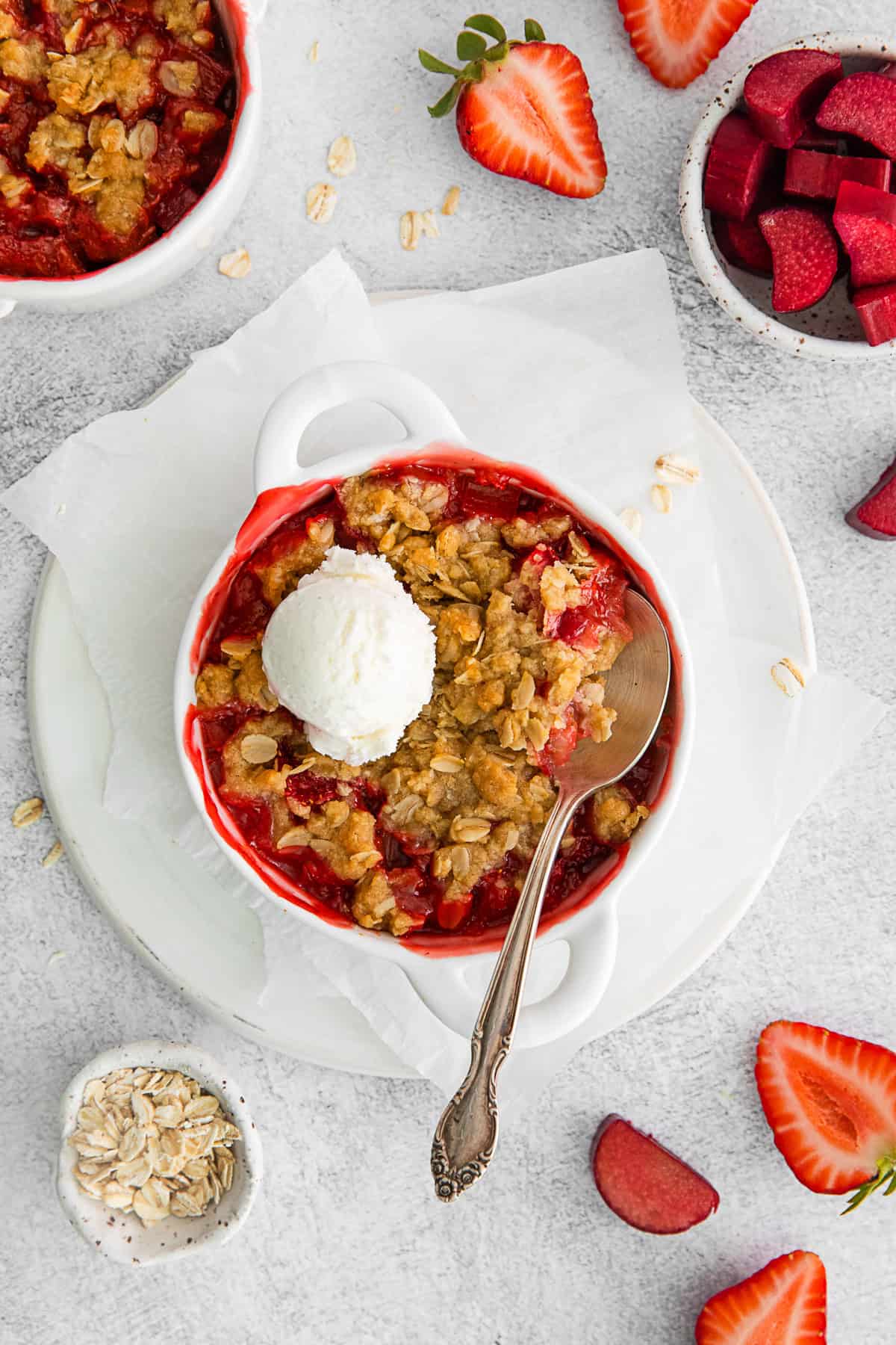 Strawberry Rhubarb Crisp in a dish topped with ice cream.
