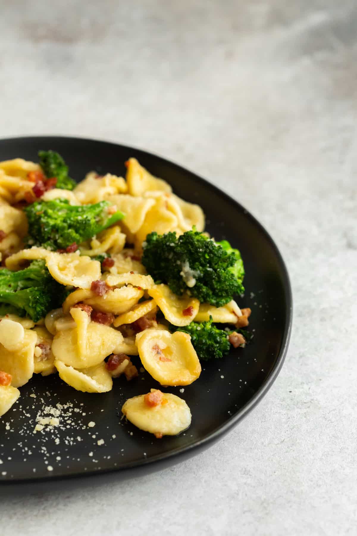 Broccoli Rabe Pancetta Pasta served with Parmesan cheese.