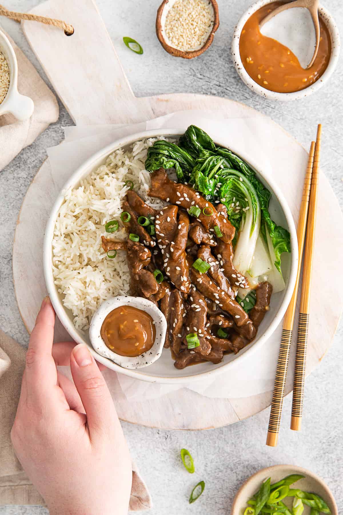 A hand holding a Beef Bulgogi Rice Bowl.