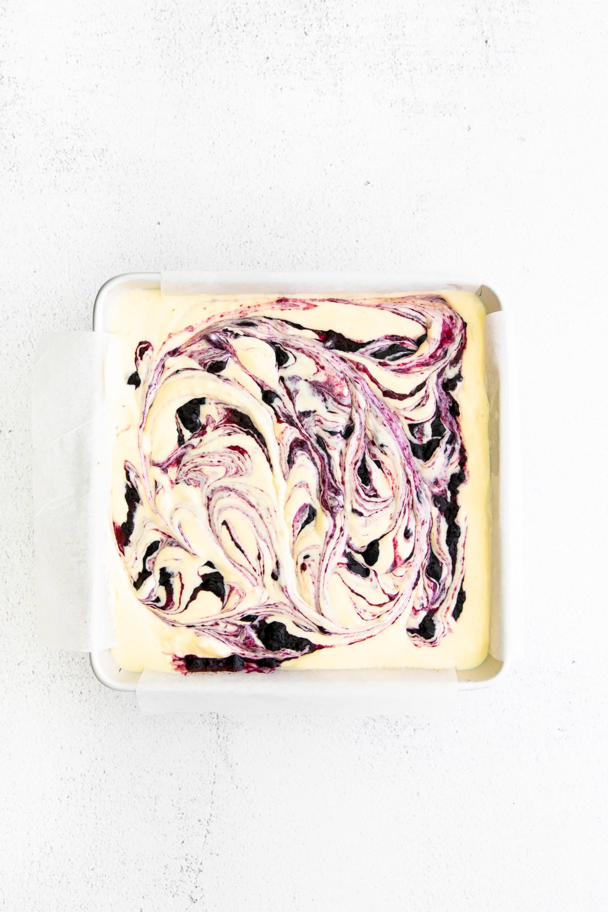 Blueberry Cheesecake Bars uncooked in a pan. 
