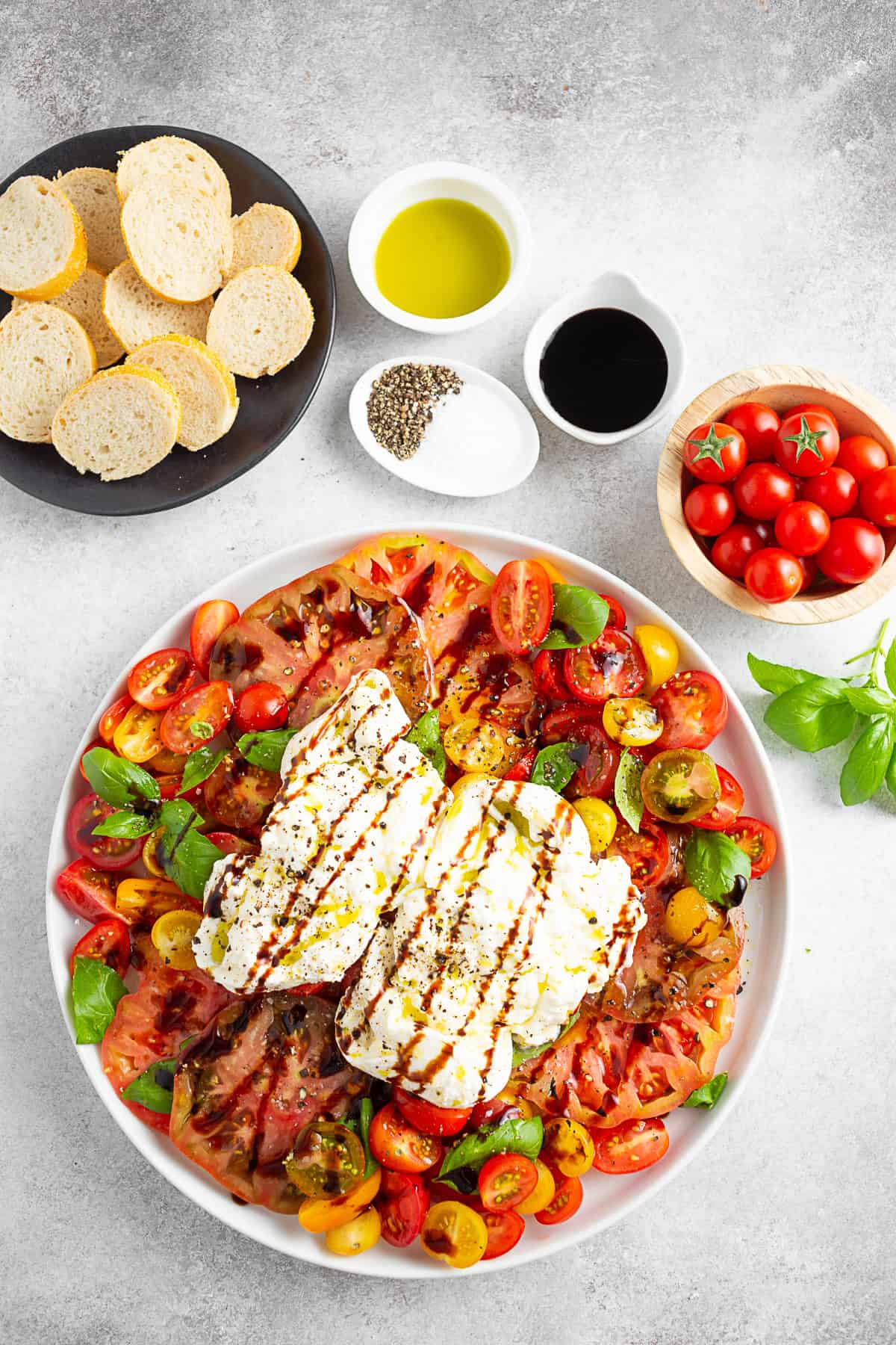 Burrata Caprese Salad on a plate with a ball of cheese on top. 