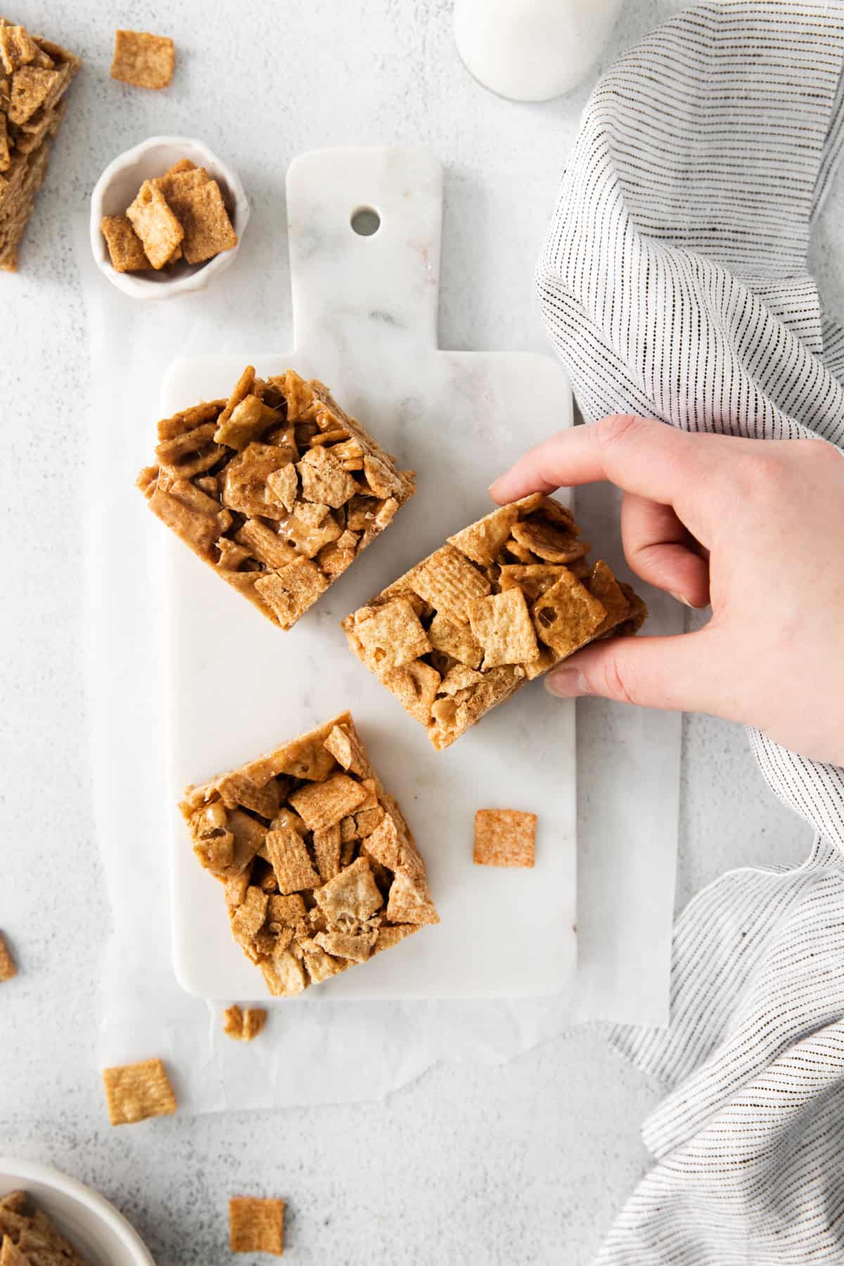 A hand grabbing a Cinnamon Toast Crunch Cereal Bar.