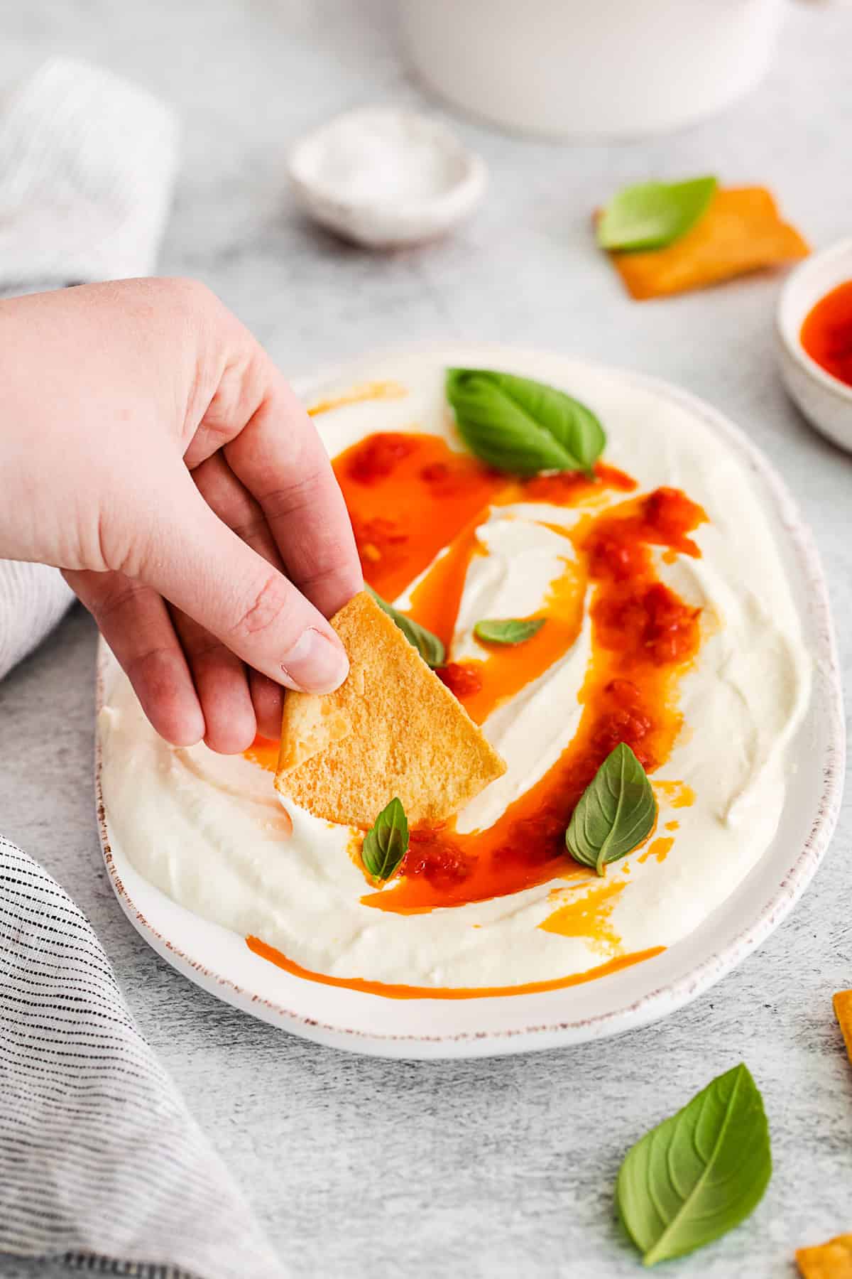 Dipping a pita chip into Harissa Whipped Feta.