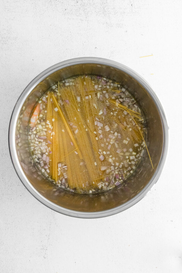 Shrimp, water, and pasta in an Instant Pot. 