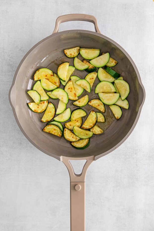 Zucchini cooking in a skillet.