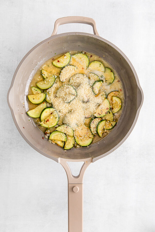 Zucchini and parmesan cheese in a skillet.