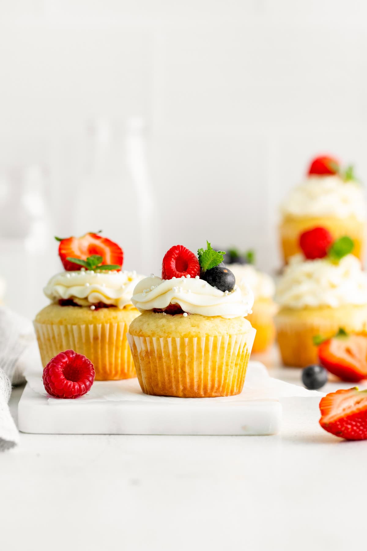 Mascarpone Berry Cupcakes on a white serving board.
