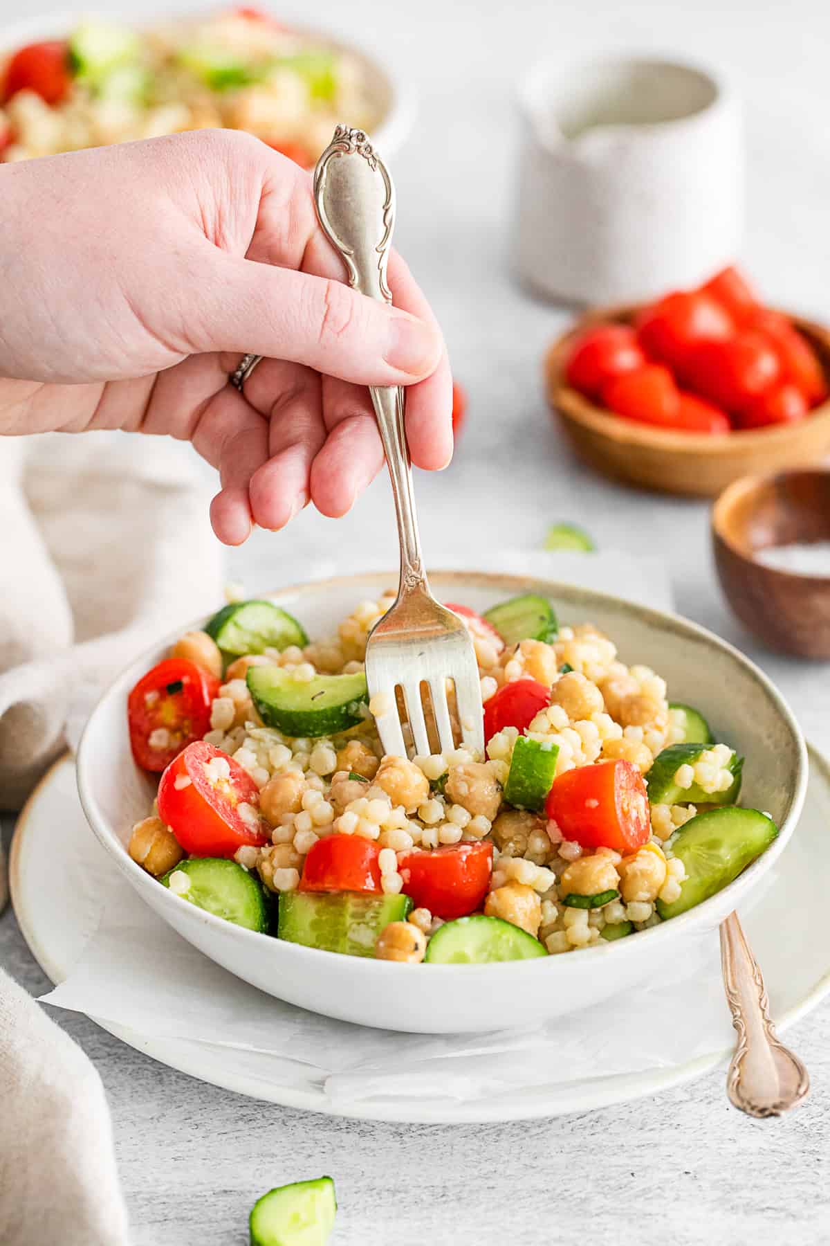 A fork taking a bite of Mediterranean Couscous Salad.