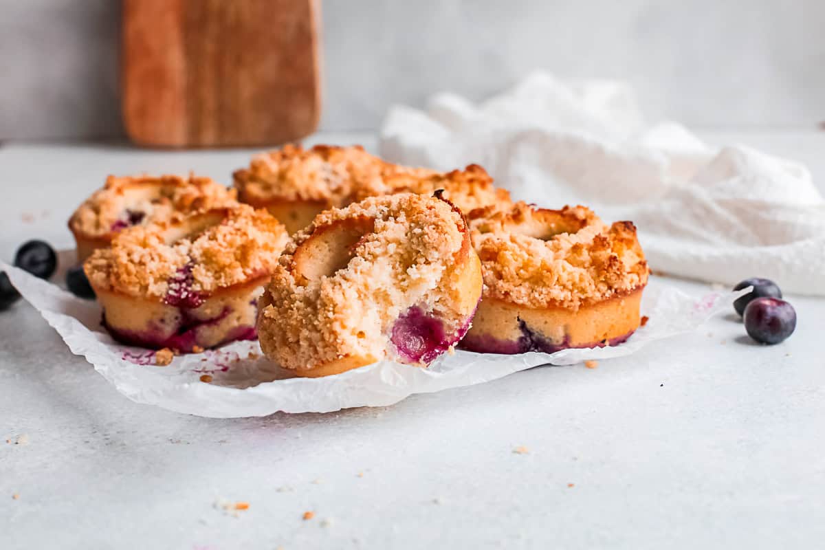 Baked Blueberry Streusel Donuts sitting on a piece of parchment paper.