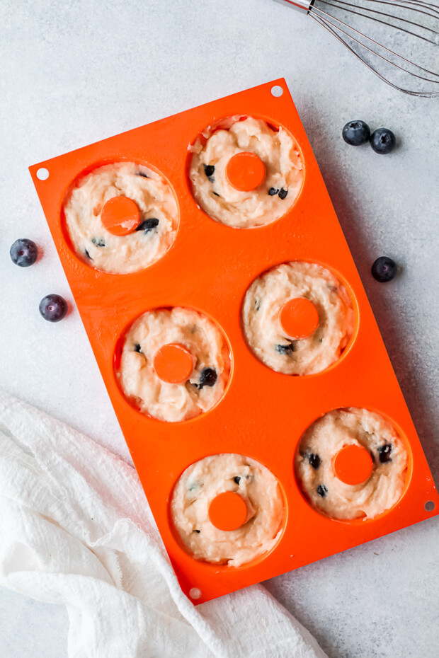 Uncooked donuts in a pan.