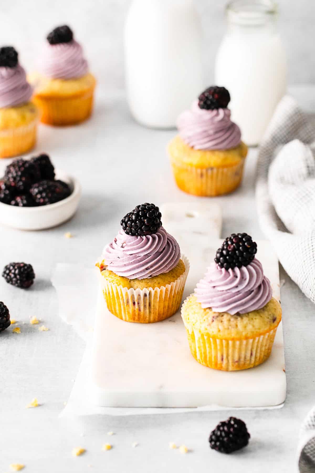 Blackberry Cupcakes topped with frosting and a fresh berry.