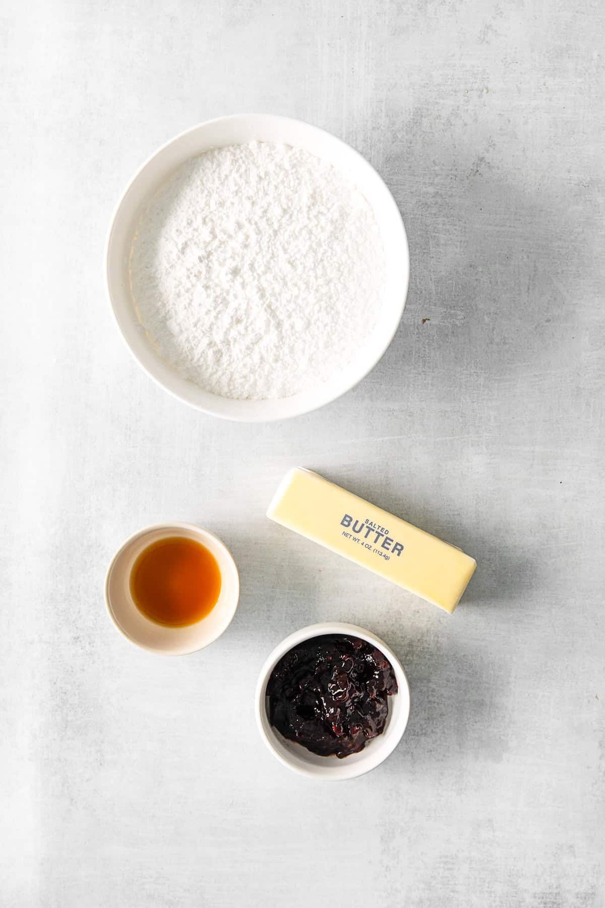 Ingredients to make blackberry buttercream on a table.