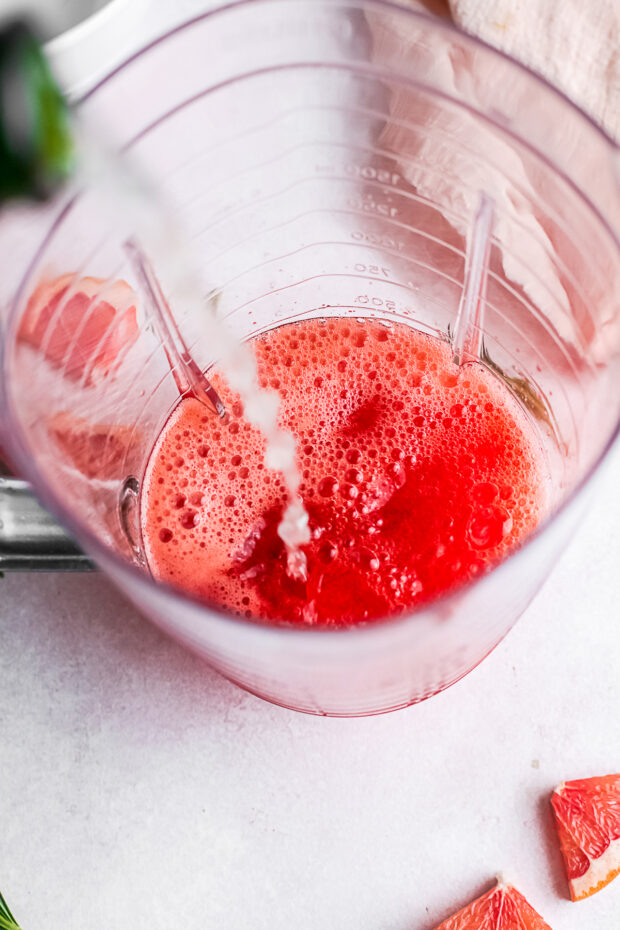 Prosecco being poured into a blender. 