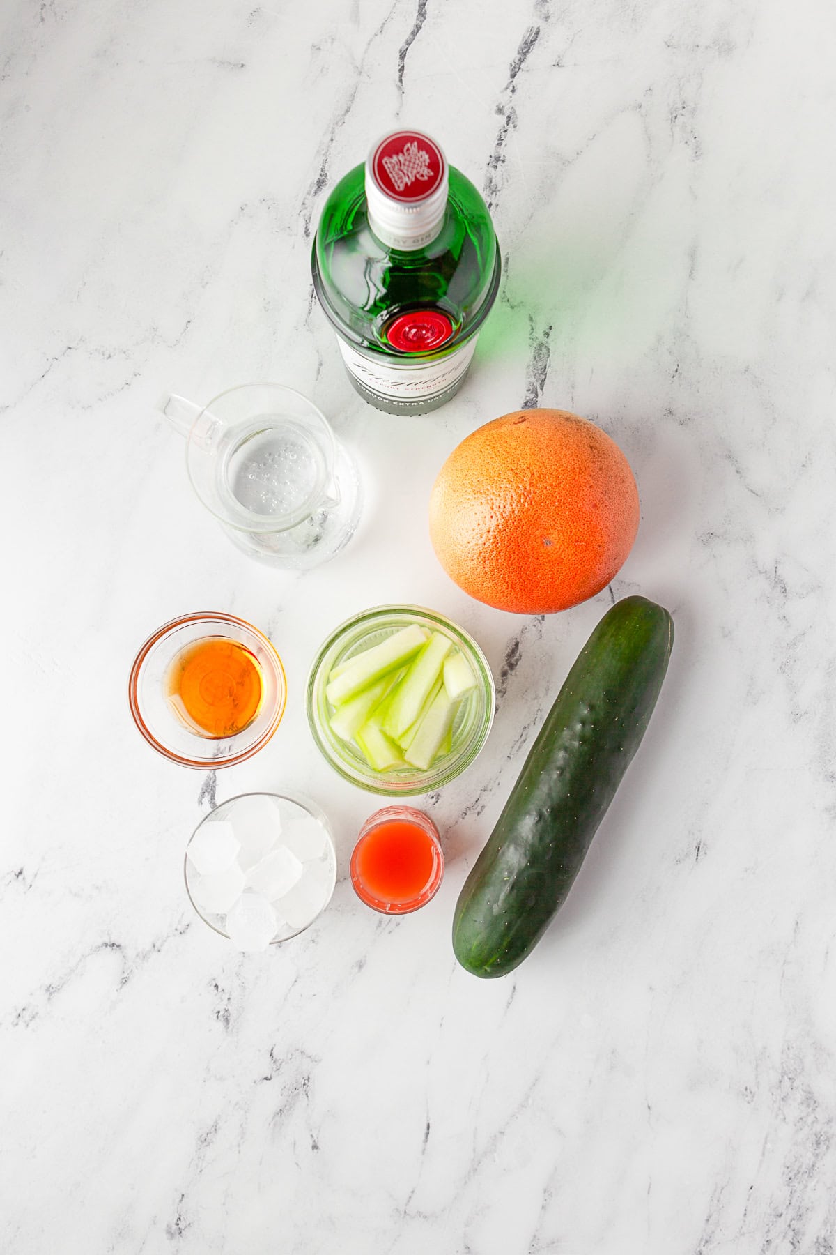 Ingredients to make Grapefruit Gin Fizz sitting on a table. 