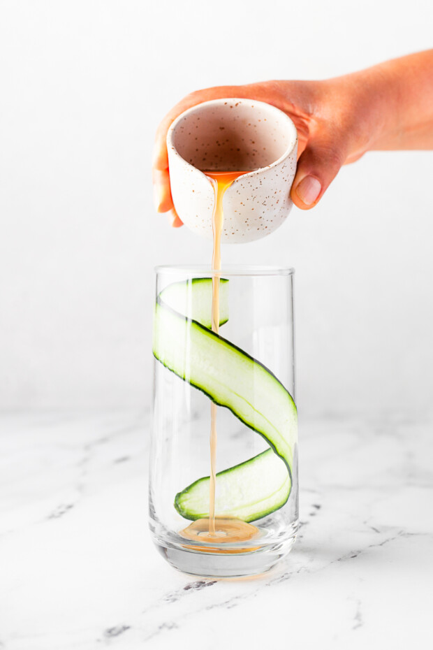 Pouring grapefruit juice into a cocktail glass. 