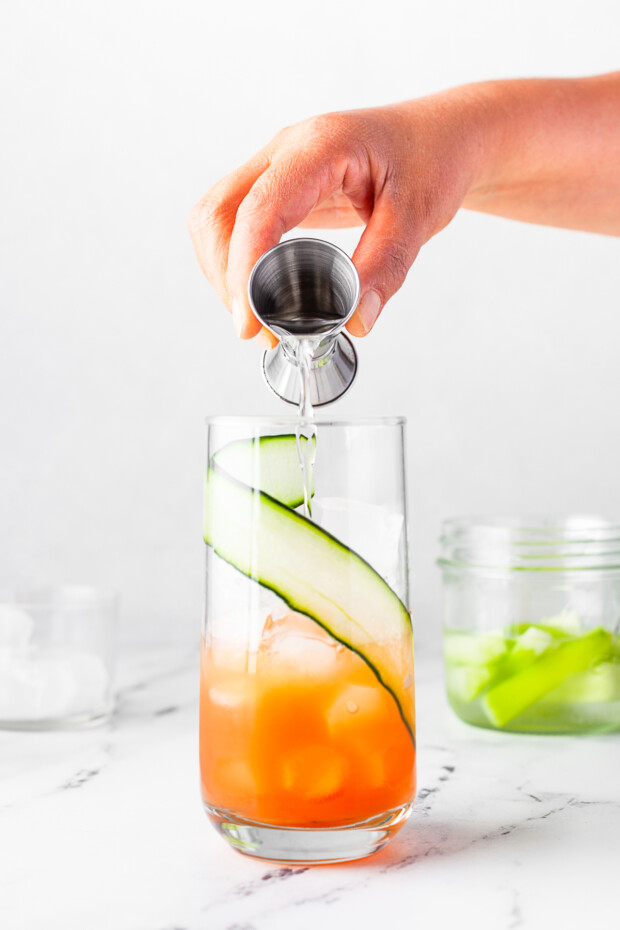 Pouring gin into a cocktail glass. 