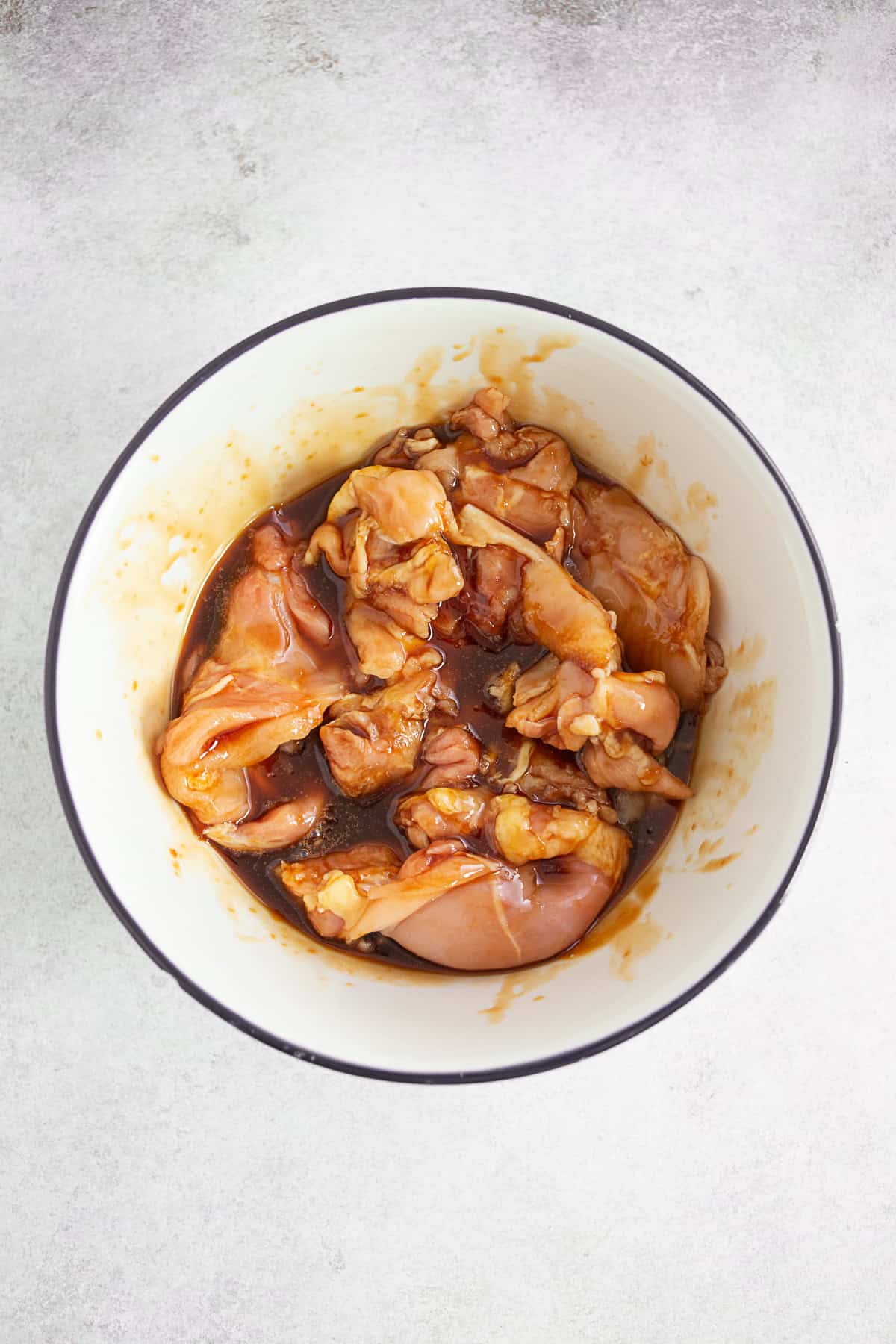 Chicken thighs marinating in teriyaki sauce.