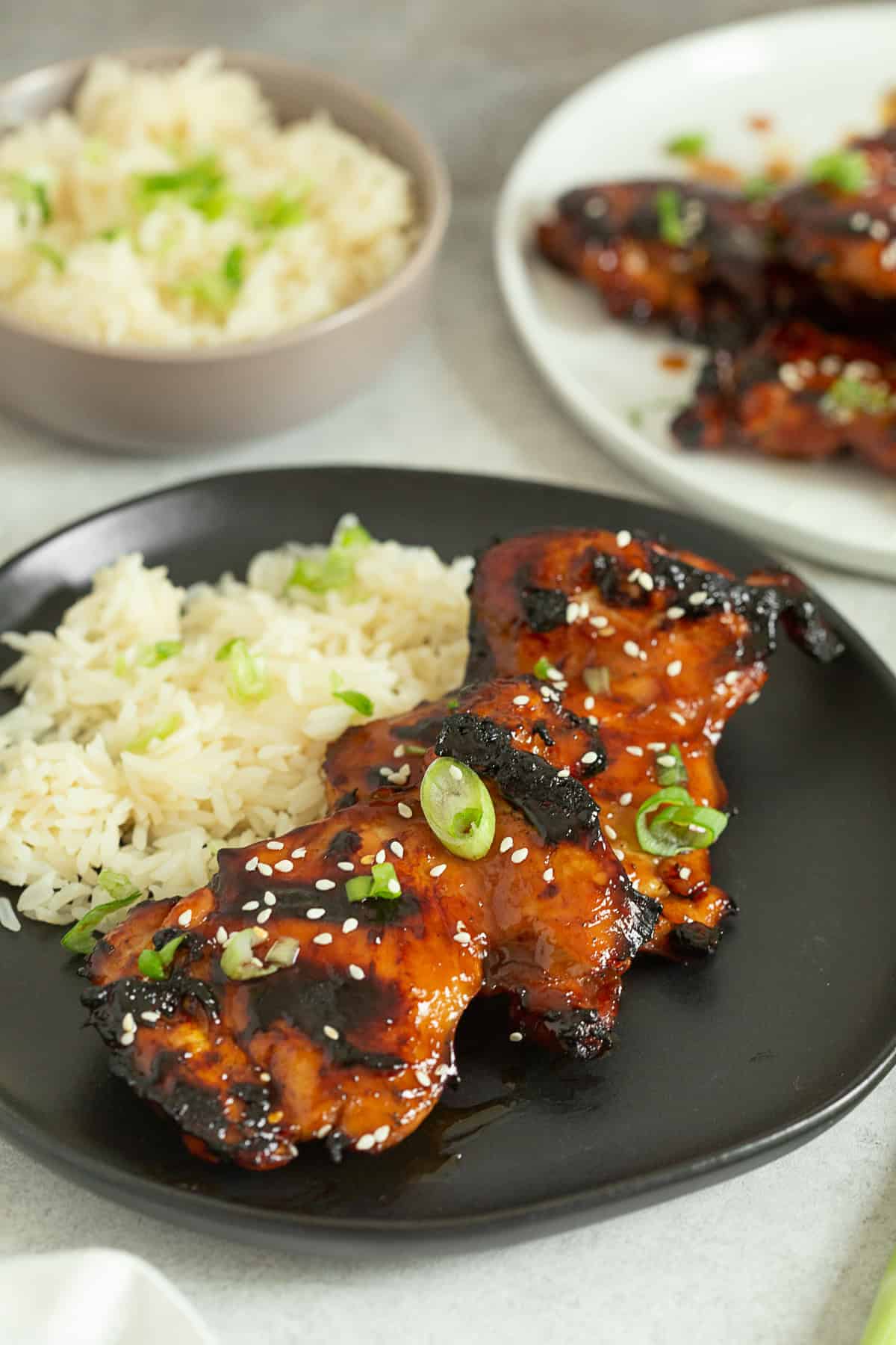 Grilled Teriyaki Chicken topped with green onions and sesame seeds with rice.