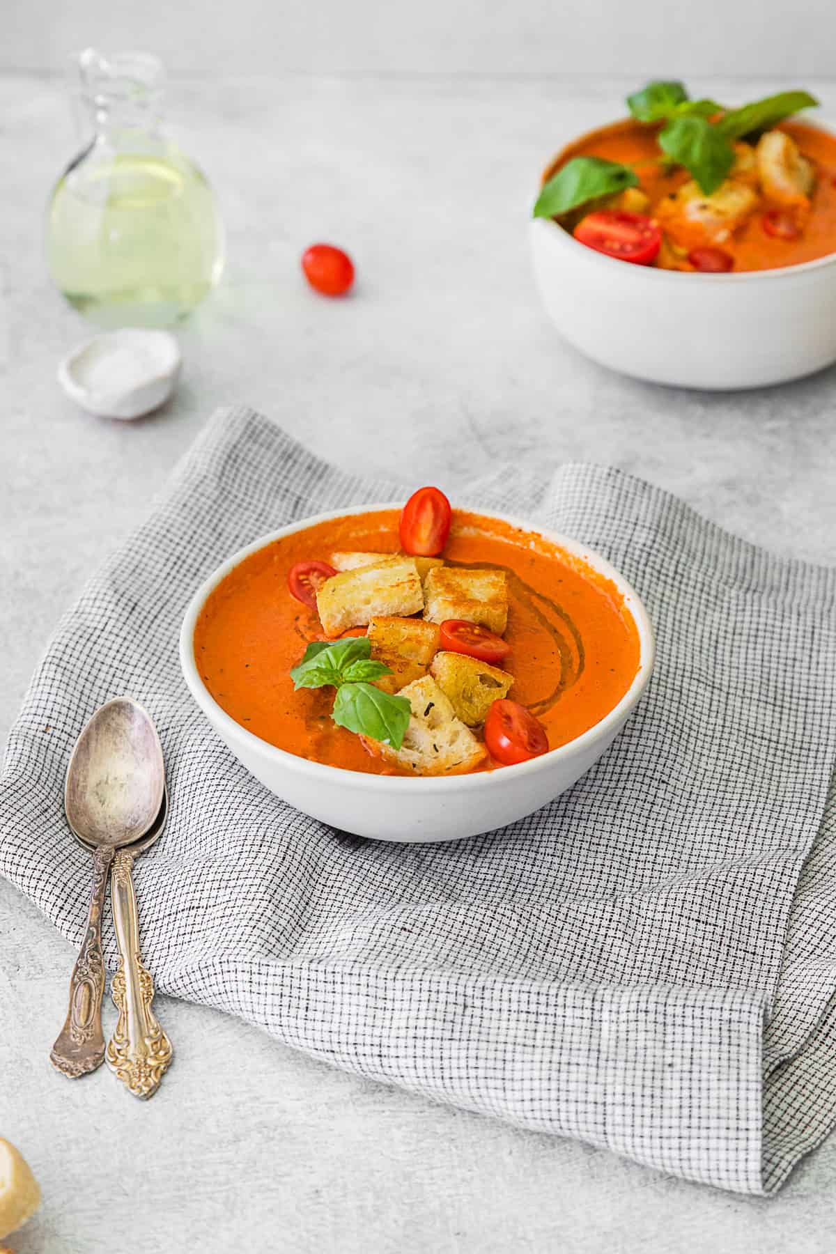 Instant Pot Tomato Soup served with a spoon and fresh basil.