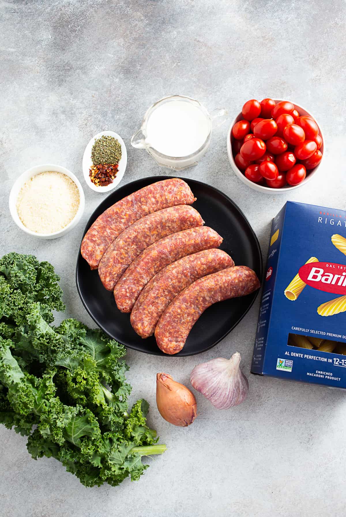 Uncooked ingredients for Italian Sausage Kale Pasta on a table. 