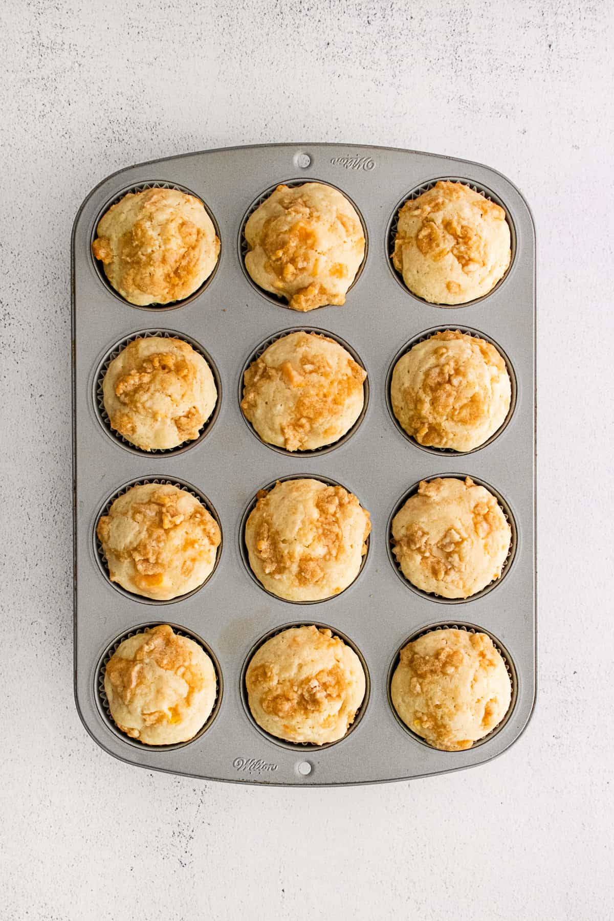 Peach Streusel Muffins cooked in the muffin tin. 