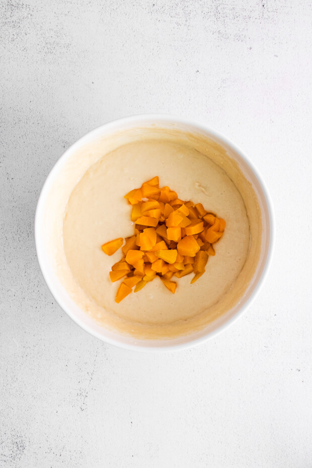 peaches in a bowl with muffin batter. 