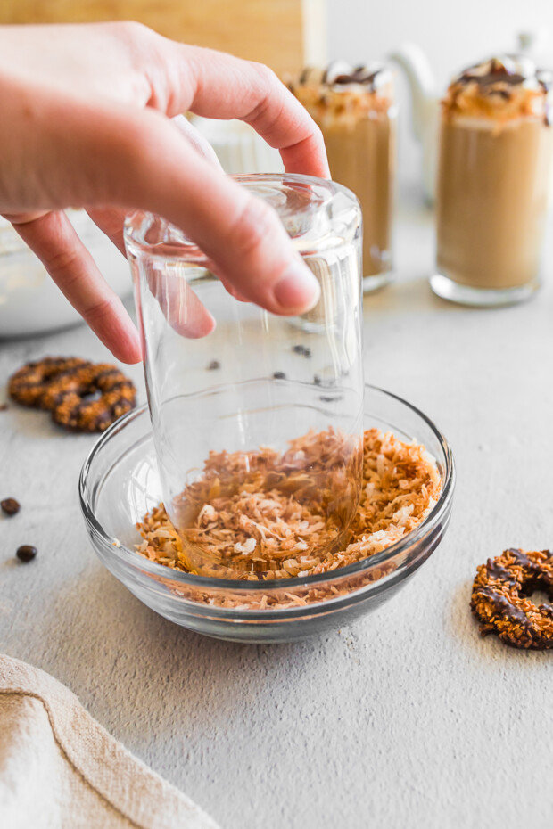 Dipping a glass into toasted coconut.