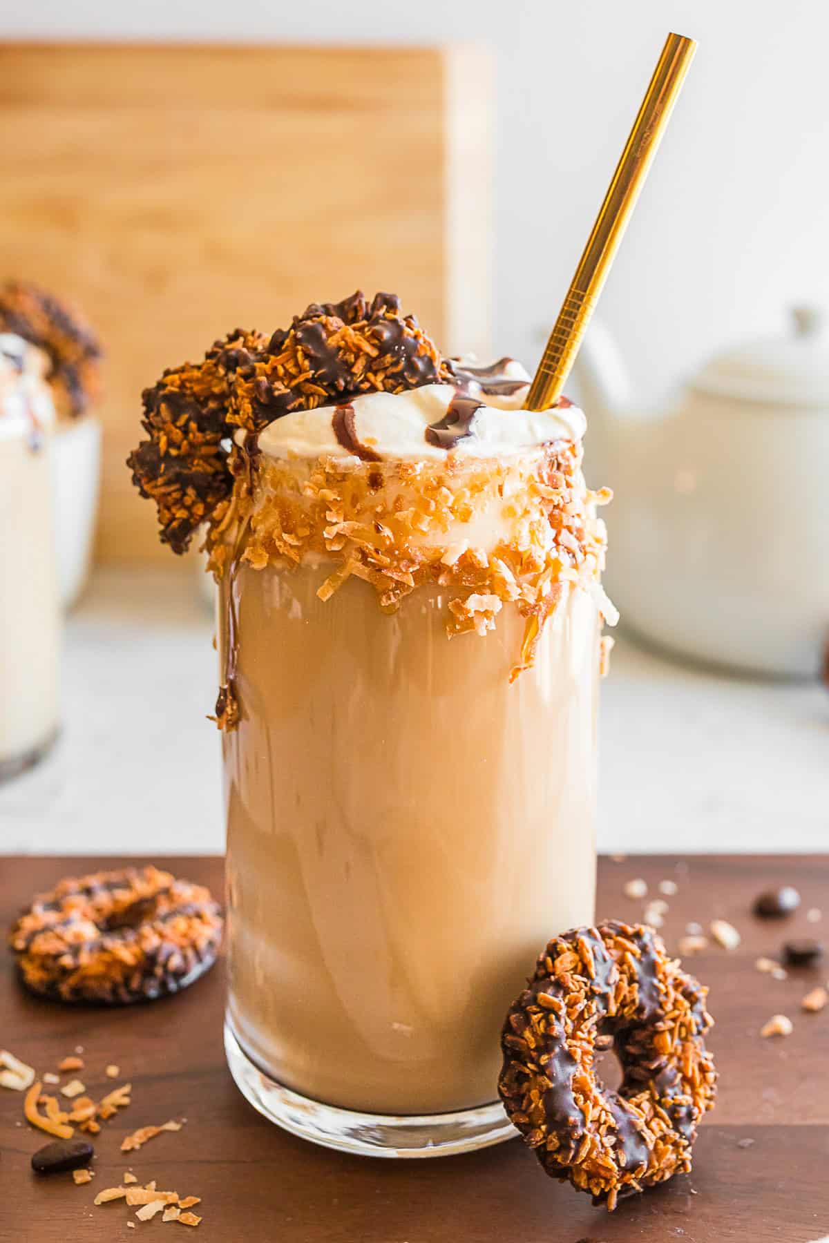Samoas Iced Coffee in a glass with a metal straw.