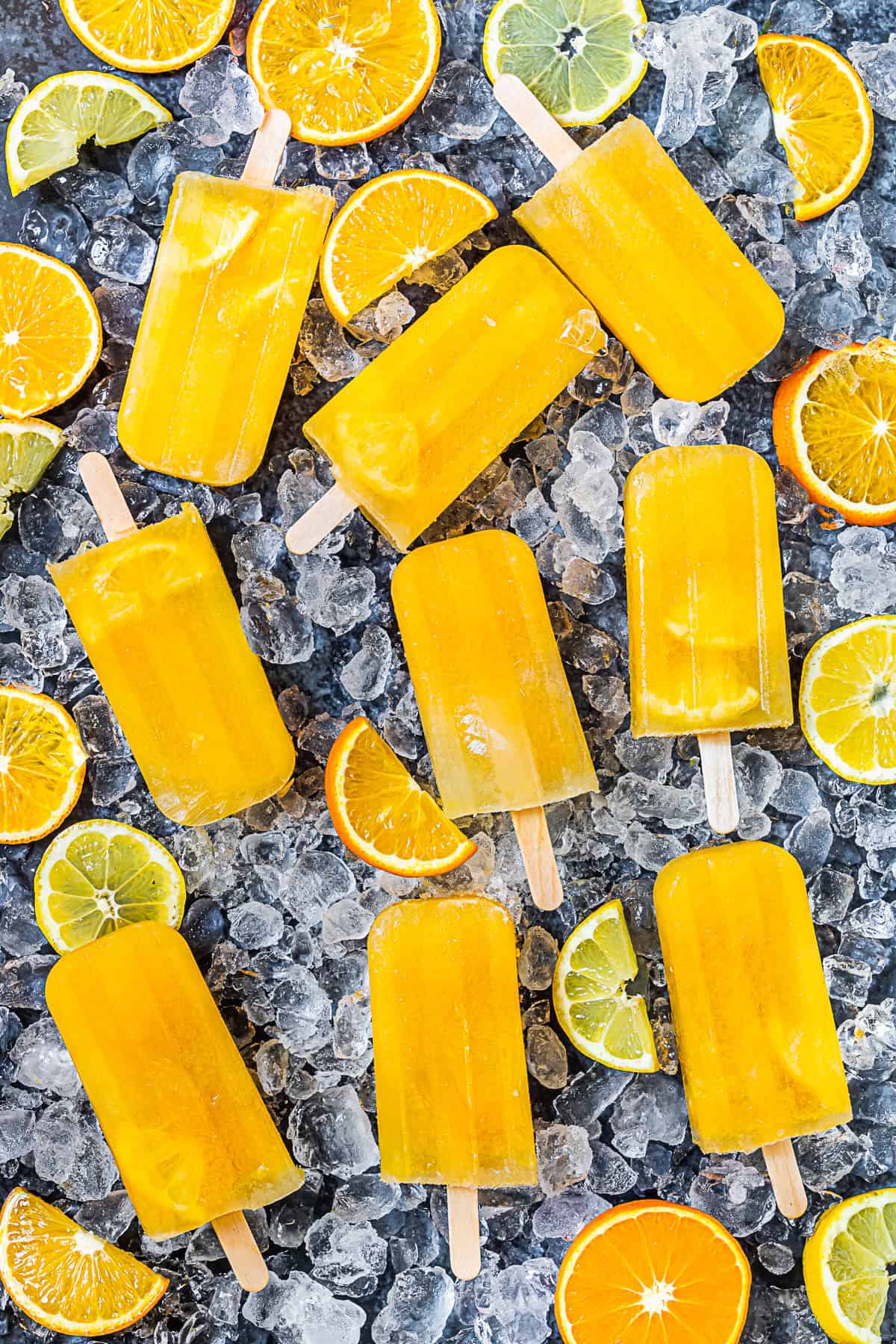 Citrus Popsicles on a table with ice.