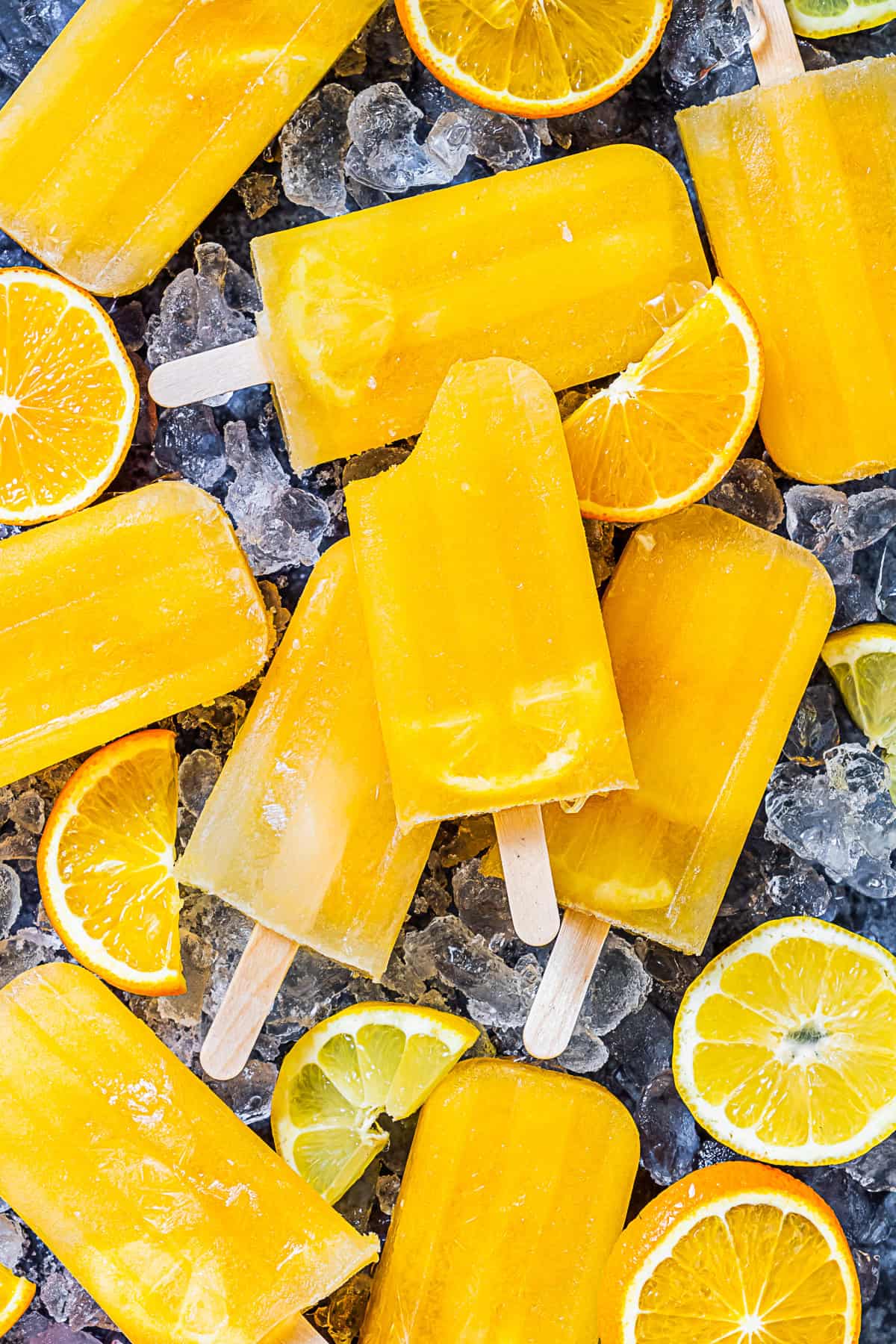 Citrus Popsicles on a table with a bite taken out of the popsicle.