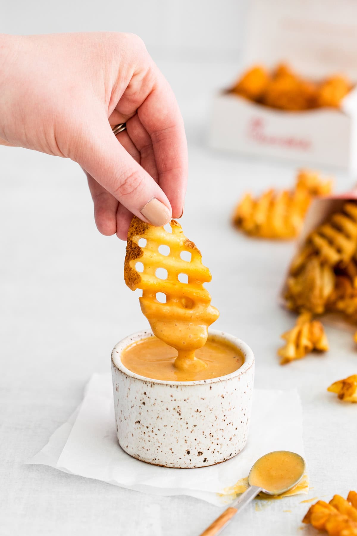 A fry being dipped into Copycat Chick-fil-A Sauce.