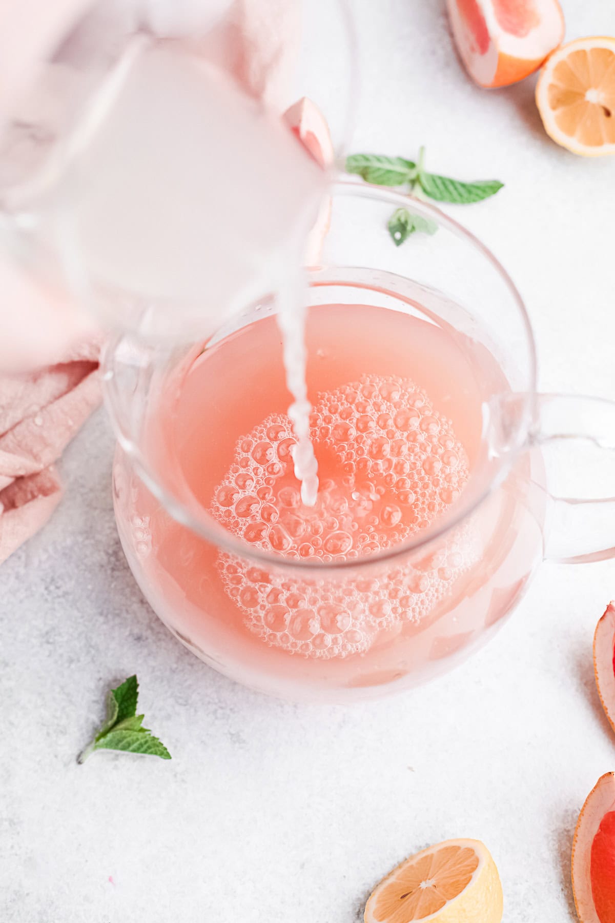 Lime juice being poured into grapefruit juice. 