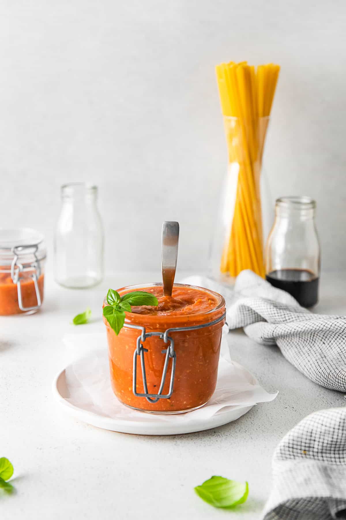 Roasted Tomato Sauce in a jar with a spoon in it. 