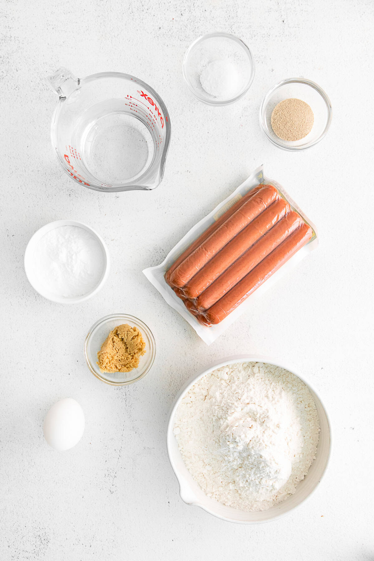 Ingredients to make homemade pretzel dogs on a table. 