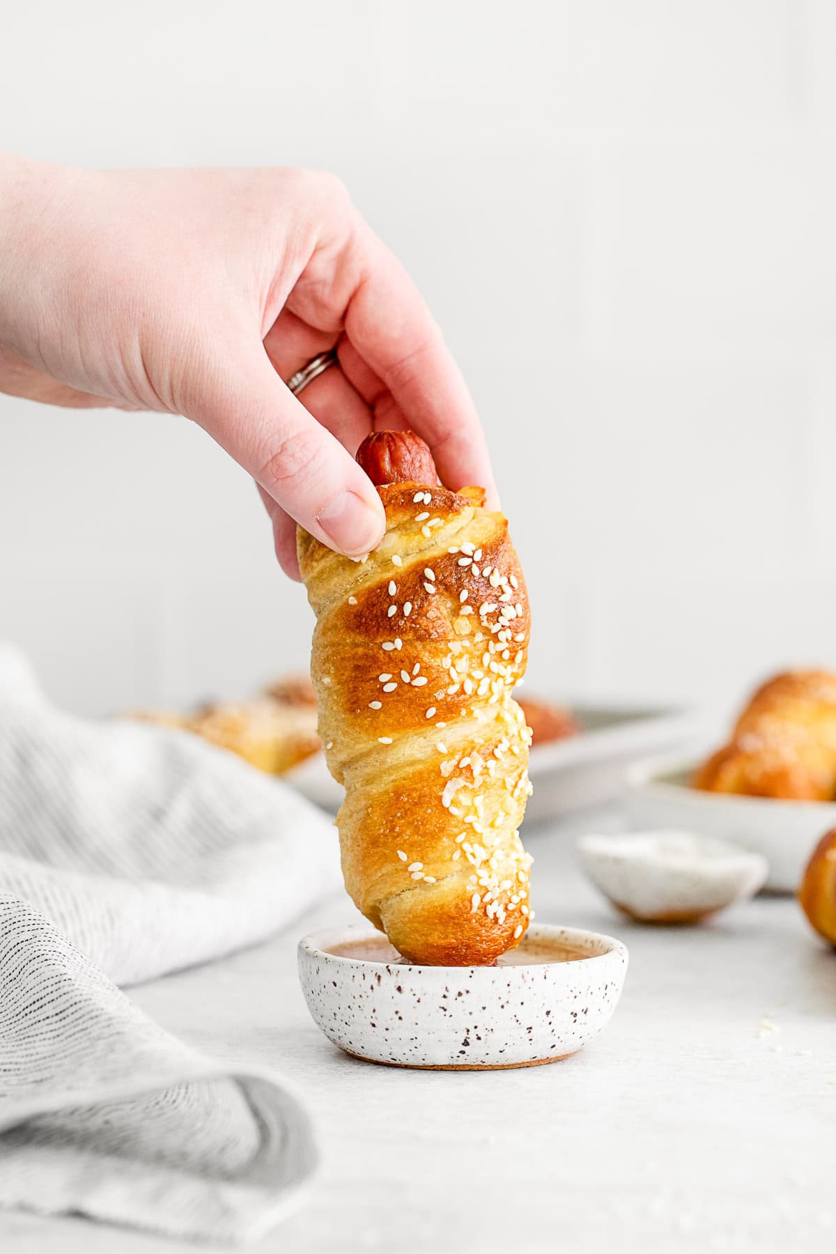 Dipping a Soft Pretzel Dog into honey mustard. 