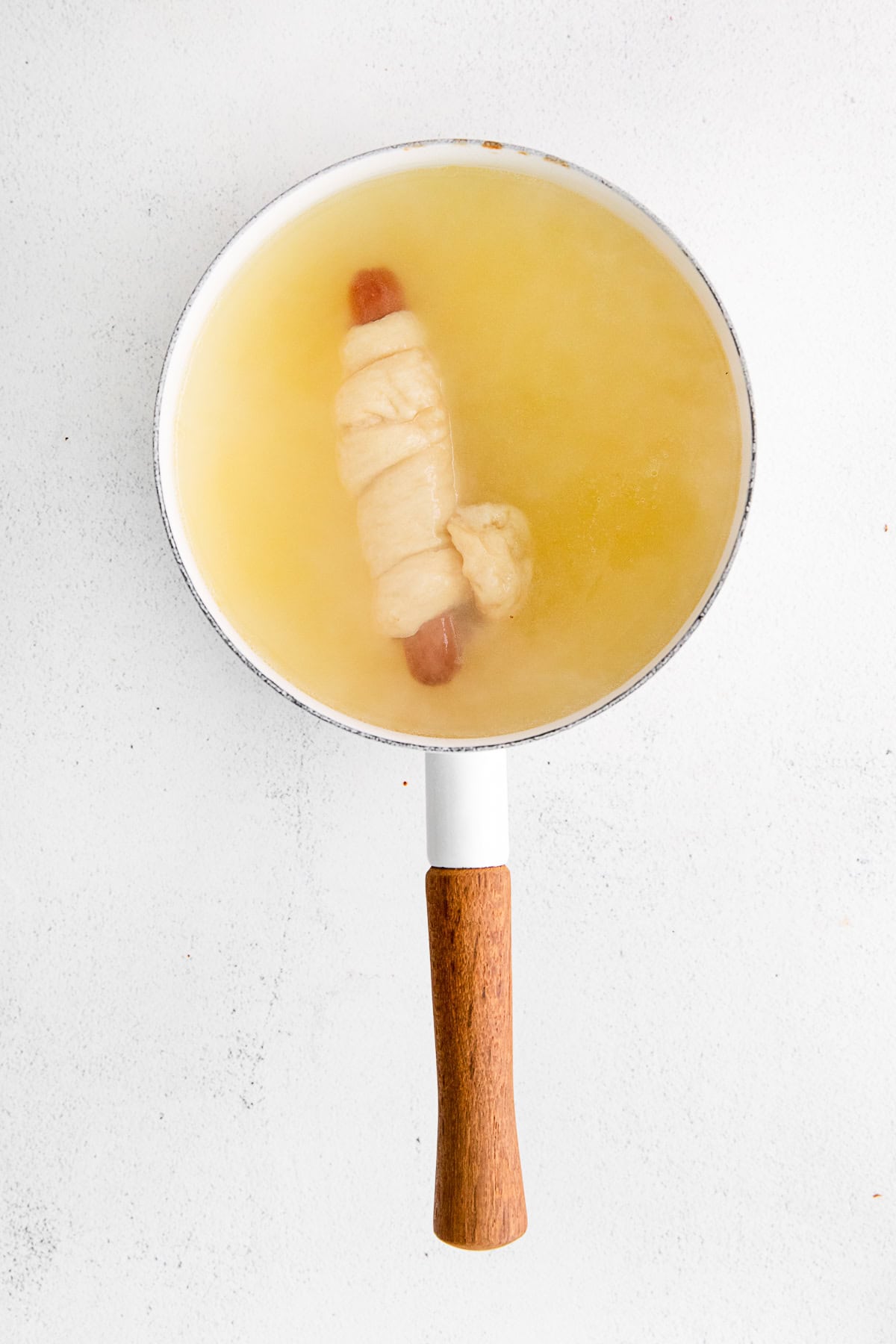 Soft Pretzel Dog floating in water. 