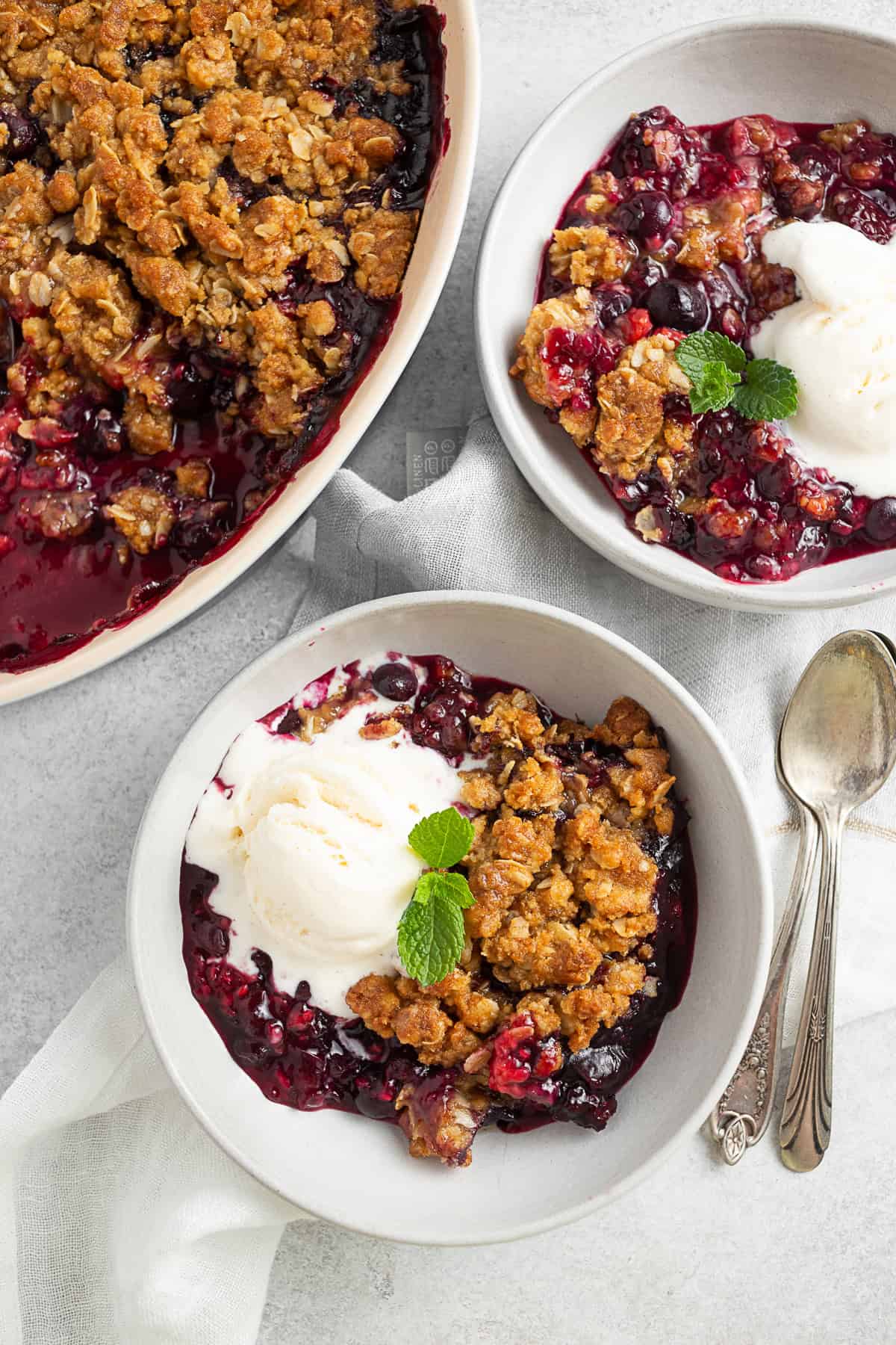 Triple Berry Crisp in a bowl with ice cream. 